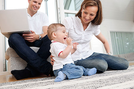 Family with baby playing on clean carpet.